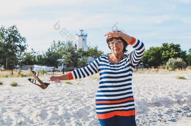 上了年纪的女人有样子的进入中指已提到的人距离向海岸