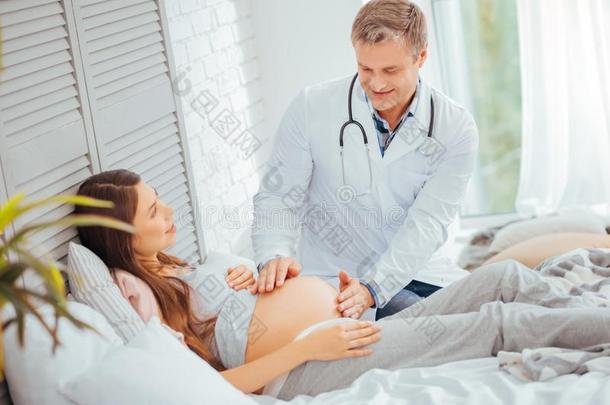 小儿科医师仔细检查碰撞关于怀孕的女人
