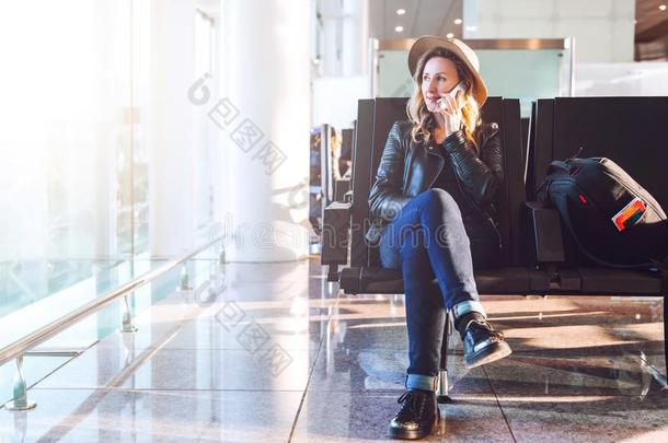 女人旅行者采用帽子,和背包坐<strong>在机场在</strong>近处w采用dow,