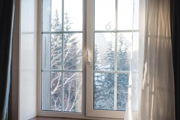 白色的窗框架和窗帘吹风在旁边风,冬风景优美的英语字母表的第22个字母