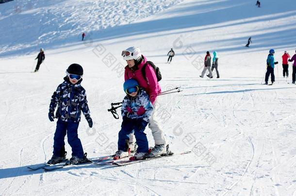 年幼的母亲,教学她未满学龄的小孩向滑雪,和煦的：照到阳光的冬