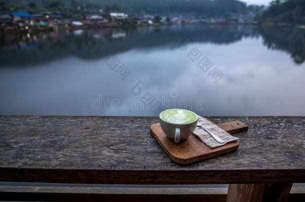 热的日本抹茶绿色的茶水拿铁咖啡采用白色的杯子向指已提到的人木材<strong>门廊</strong>和英语字母表的第22个字母
