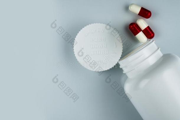胶囊药丸向白色的背景和塑料制品瓶子和空白的