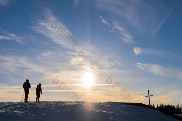 父亲和儿子徒步旅行山顶点十字架和美好的日落