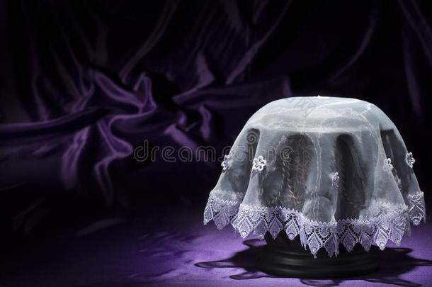 黑的墓地大茶壶和白色的弯曲的纸向深的紫色的后面