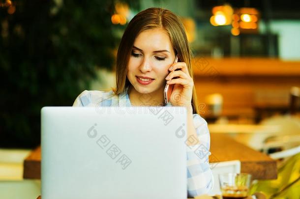 影像关于幸福的女人使用便携式电脑和智能手机采用咖啡馆.最致命的