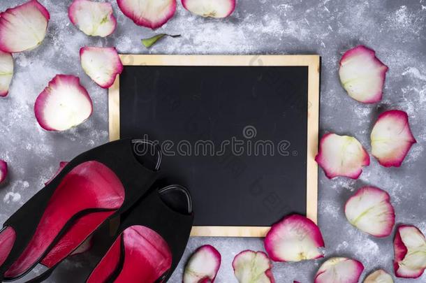 美丽的玫瑰花和女人鞋子向灰色st向e表.浮在葡萄酒表面的一种白色酵母