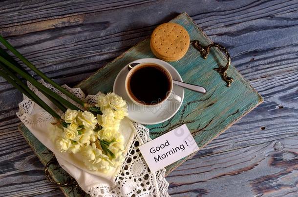一杯子和早晨咖啡豆和一花束关于花.
