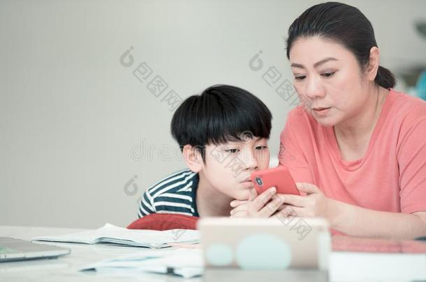 亚洲人男孩和母亲教学和学<strong>问你</strong>的家庭作业在homonym同音异义词