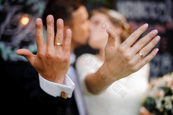 新郎和新娘接吻的和展映婚礼戒指向他们的