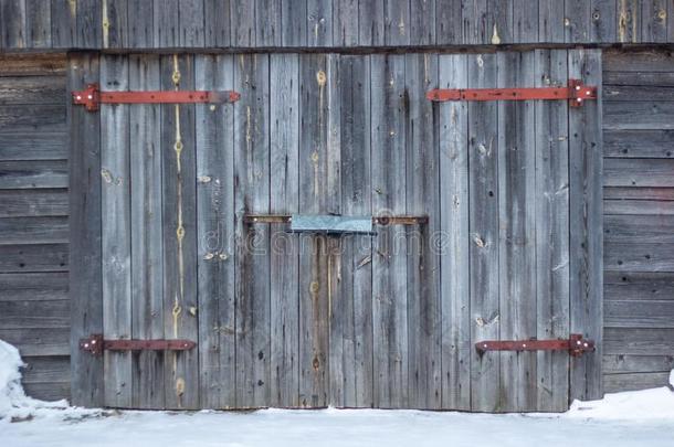 车库建筑物的正面和老的灰色木制的门.老的车库门
