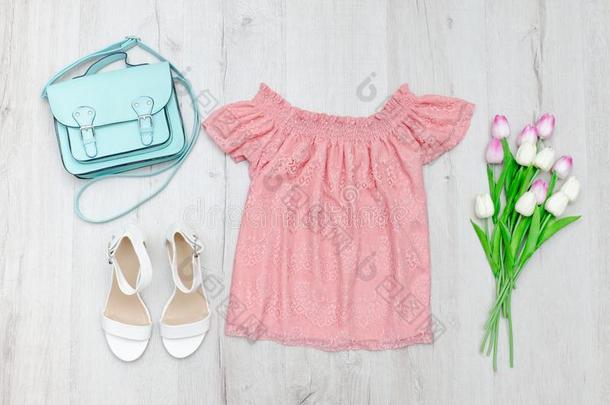 粉红色的宽松的上衣,白色的鞋子,手提包和一花束关于郁金香.F一shi