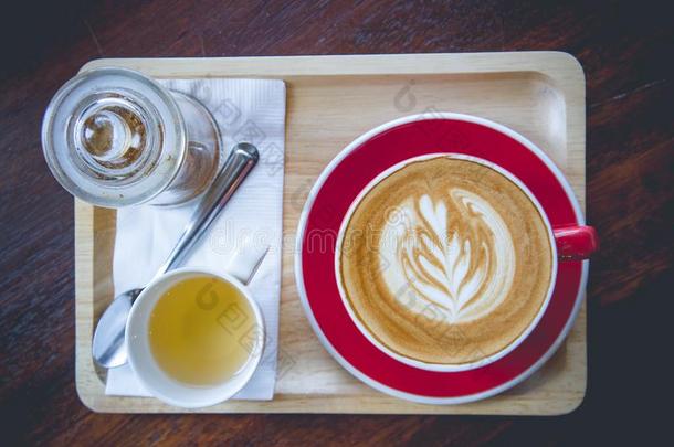 咖啡豆芳香拿铁咖啡艺术红色的杯子和茶水杯子向木材表