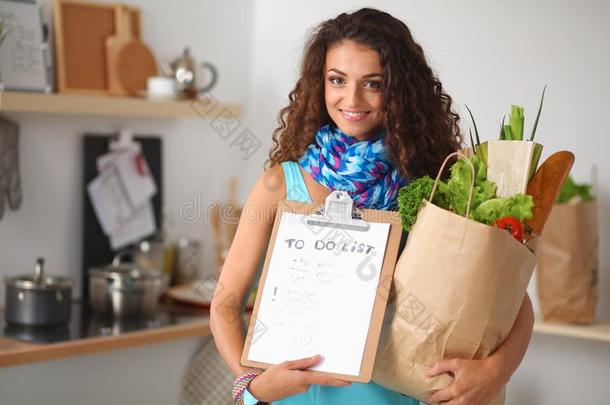 年幼的女人佃户租种的土地食品杂货店购物袋和蔬菜替身