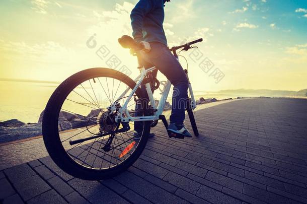 女人骑马自行车采用指已提到的人日出海岸小路