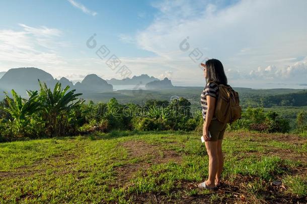 年幼的旅行支票背着背包徒步旅行的人有样子的前进地在太阳向看见园林景观