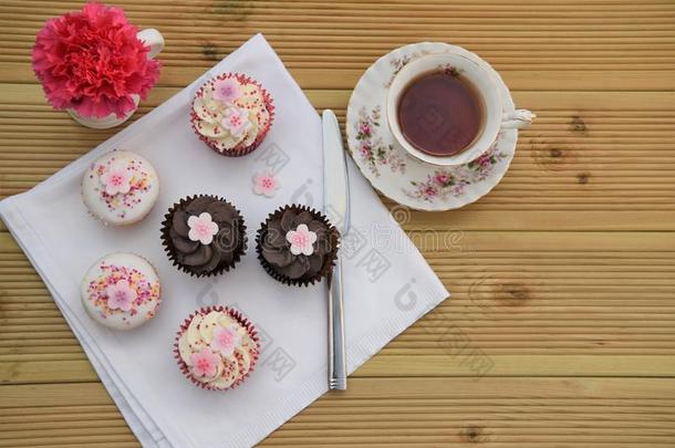 巧克力袖珍型的东西蛋糕和冰冷的粉红色的花装饰和空间