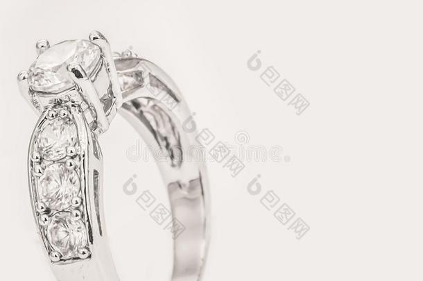 白色的金钻石戒指向白色的乳霜背景