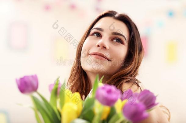 有魅力的女人安排郁金香花采用装饰瓶