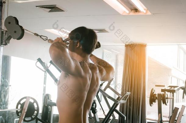 亚洲人男人<strong>拉条</strong>重量在室内的健身房.
