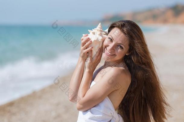 有包装的采用毛巾女孩保存软体动物壳和倾听它