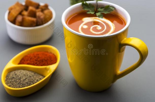 红色的热的番茄汤采用一黄色的杯子