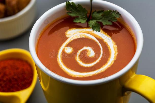 红色的热的番茄汤采用一黄色的杯子