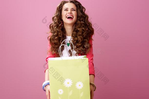 欢乐的现代的女人隔离的向粉红色的礼物购物袋