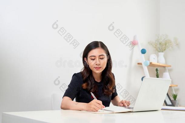 女人学习和便携式电脑和迷人的记下向一桌面一t家