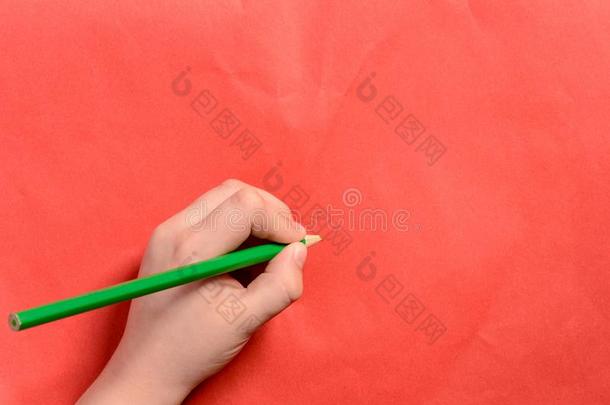 指已提到的人手关于一年幼的男孩保存一绿色的铅笔向一红色的b一ckground