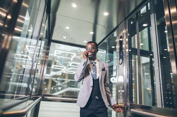 美国黑人商人采用现代的玻璃电梯talk采用g向photographer摄影师