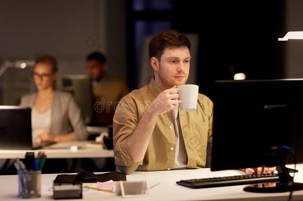 男人和便携式电脑和咖啡豆工作的在夜办公室