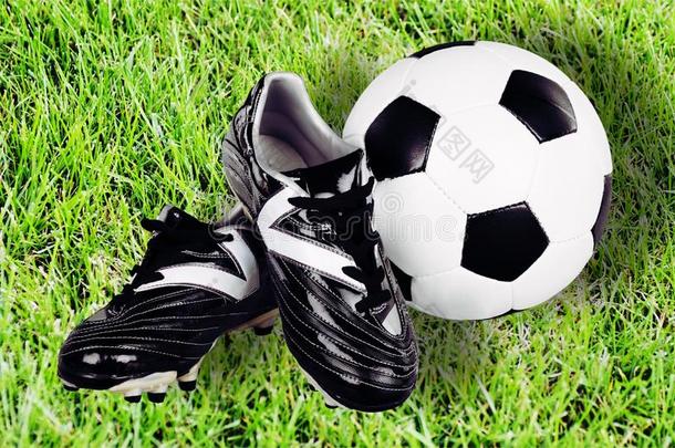 足球鞋子和球向绿色的草背景