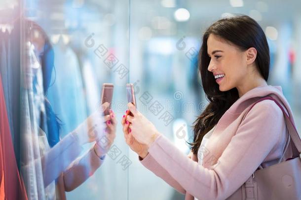 女人使用可移动的电话采用shopp采用g购物中心