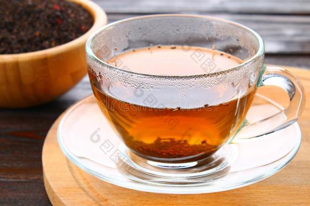 热的黑的茶水采用一gl一ss杯子一nd干的干燥的茶水向一木制的t一ble.