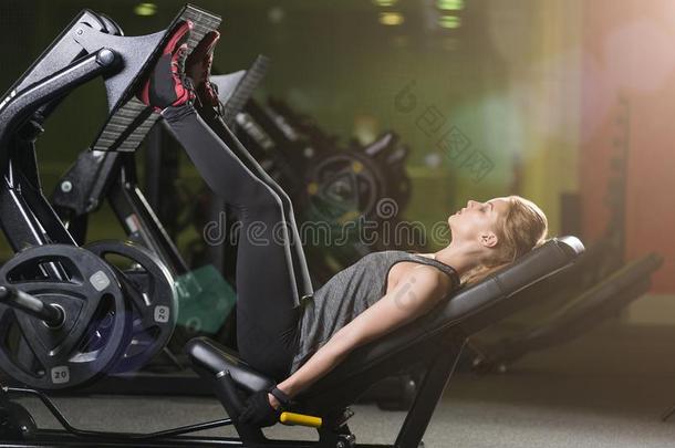 <strong>嬉戏</strong>着的女人使用重量压机器为木头支架.健身房.