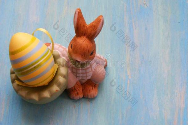 复活节野兔和有色的鸡蛋,复活节兔子数字向蓝色木制的