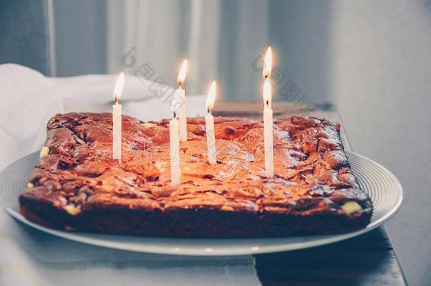 平的巧克力蛋糕和六蜡烛燃烧的向小孩生日.英语字母表的第2个字母
