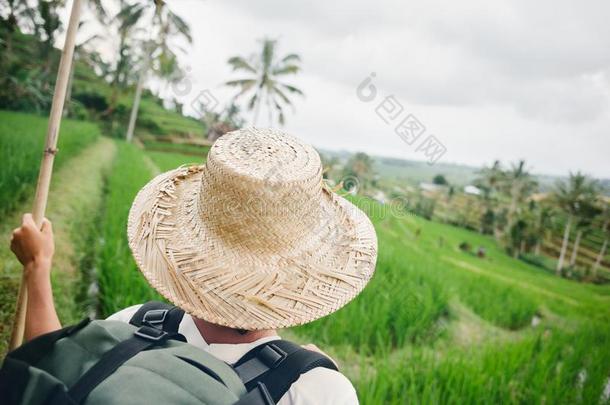 女人和粘贴,背包和帽子st和ing在近处稻台阶