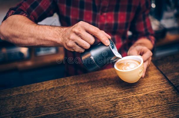 咖啡馆准备咖啡的员工创造拿铁咖啡艺术和卡普契诺咖啡在地方的小酒馆,酒馆