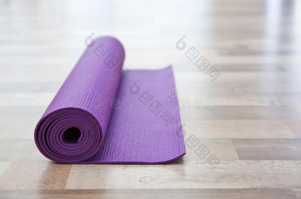 紫色的瑜伽席子向木制的地面
