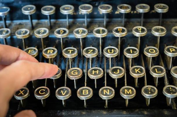 老的打字机键盘和手指打字关-在上面