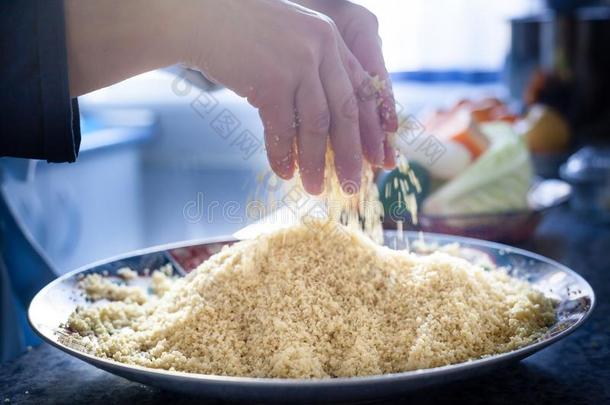 厨师手准备的蒸粗麦粉传统的摩洛哥的盘子.