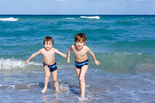 两个<strong>小孩</strong>男孩<strong>跑步</strong>向洋海滩.小的孩子们所有乐趣