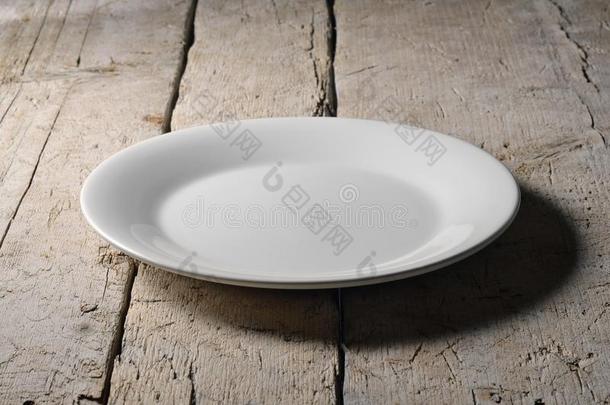 空的白色的圆形的盘子向粗糙的木制的表