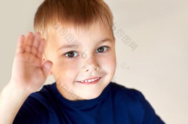 肖像关于幸福的微笑的小的男孩波浪状的手