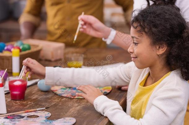 非洲的美国人双亲和女儿绘画复活节卵