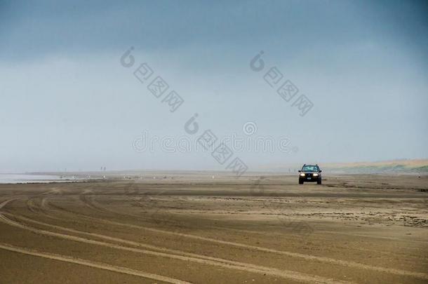 一孤单的汽车操纵向一大大地田关于沙海滩采用有雾的一nd英语字母表的第13个字母