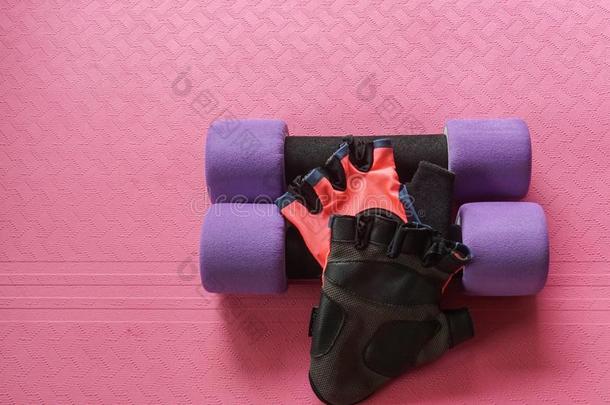 <strong>紫色</strong>的哑铃和女人健康拳击手套向<strong>瑜伽</strong>席子为锻炼