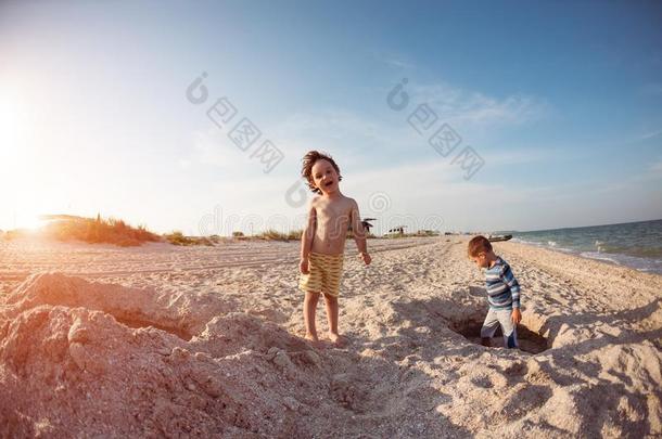男孩演奏和沙向指已提到的人海滩.